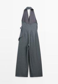 Combinaison grise sans manches à jambes larges avec un profond décolleté en V et un col style halter, en tissu léger, présentée à plat sur fond blanc.