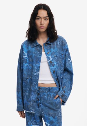 Blauwe spijkerjack met bloemenpatroon, knoopsluitingen en opgestikte zakken. Beschikt over een relaxed fit en een gestructureerd oppervlak, gecombineerd met bijpassende broek.