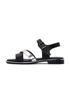 Black and silver leather sandals with an open toe, two crisscross straps, adjustable ankle strap, and a low, flat sole.