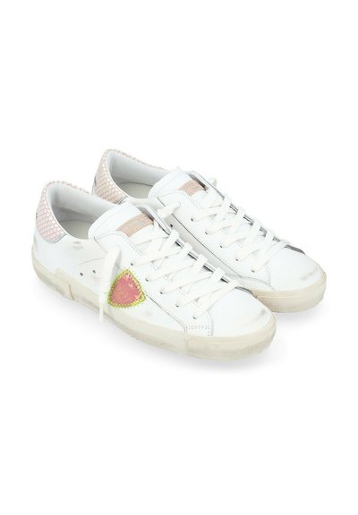 Sneakers bianchi con una parte posteriore rosa testurizzata, una toppa a triangolo verde e rosa, e lacci bianchi. Suole in gomma leggermente consumate.