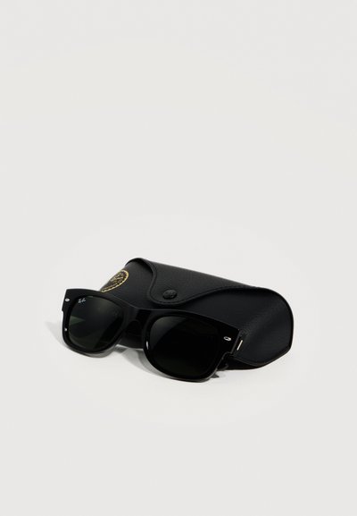 Черни слънчеви очила Ray-Ban с тъмни лещи, поставени върху черен кожен калъф с капак с копче на едноцветен фон.