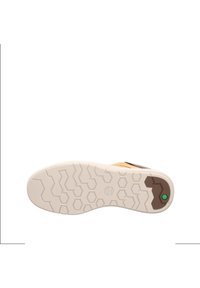 Suela de zapato con una base de goma blanca estampada, presenta grips hexagonales, y un diseño superior en marrón y amarillo con un detalle en verde.