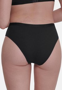 Zwarte katoenen hooggetailleerde slips met een zachte tailleband, naadloze randen en geen zichtbare patronen of hardware-details.