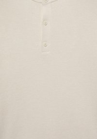Cămașă henley de culoare crem, cu nervuri, având un guler cu trei butoane, caracterizată printr-o textură moale și un design casual.