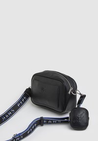 Bolso de cuero negro cruzado con un acabado texturizado, forma rectangular, herrajes plateados y una correa con diseño que presenta "PEPE JEANS" en azul y blanco.