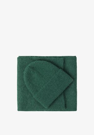 Grøn strikket tørklæde og matchende hue, lavet af blødt, tekstureret materiale. Tørklædet er rektangulært, mens huen har en rund krone.