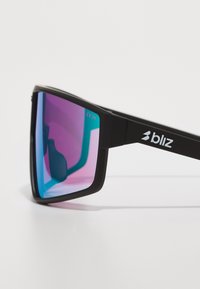 Black plastic sunglasses with a geometric shape. Lenses transition from pink to blue. Brand logo "bliz" on the temple. CE marking present.