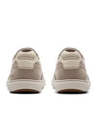Beige suède sneakers met een textuur aan de achterkant, witte zolen en subtiele branding op de hiel. Glad vooraan met minimale stiksel details.