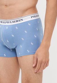 Kék boxer alsónadrág, fehér Polo Ralph Lauren logós szalaggal, melynek anyagán ismétlődő kis fehér ló logó minta található.