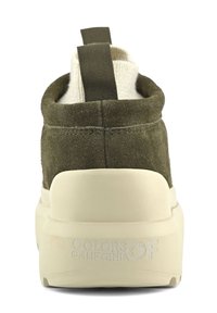 Botines de ante verde oliva con un cuello de punto crema y suela de goma marrón. Presenta un tirador en la parte trasera y un logo en relieve en el talón.