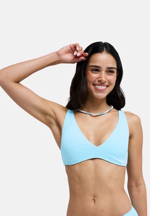 Haut de bikini bleu clair avec un décolleté en V, motif de feuilles texturé, larges bretelles et finition lisse. Le modèle porte un collier de perles.
