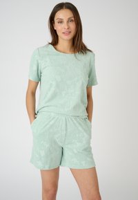 Licht mintgroen loungewear-set met een kortgeërugde top met een textuur van bloemenpatroonen en bijpassende shorts met een elastische tailleband.