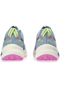 Zapatillas de trail running con un upper azul claro, acentos en neón verde y rosa contrastantes, entresuela blanca y suela texturizada rosa.