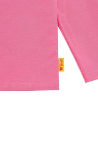 T-shirt rosa con maniche corte, realizzata in morbido cotone. Presenta un orlo dritto e un'etichetta gialla con il logo del marchio cucita di lato.