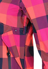 Giacca colorata con motivo a scacchi in rosa, arancione e blu navy, dotata di una tasca con zip e tessuto strutturato.