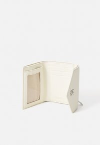 Portefeuille en cuir couleur crème avec porte-cartes intérieur, un emplacement transparent pour carte d'identité, et un détail logo argent embossé sur le devant.