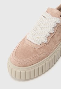 Light pink suede sneaker with a thick beige rubber sole and textured white knitted laces, featuring rounded toe and stitched accents.