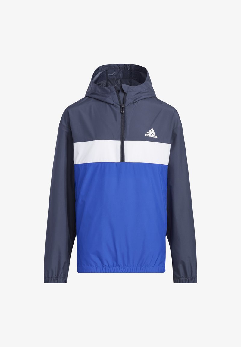 Chaqueta cortavientos de color azul marino y azul real con una franja blanca. Cuenta con capucha y cremallera de longitud cuartas. Textura suave.