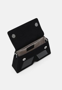 Zwarte suede clutch met een open klep, grijs interieur, twee magnetische drukkers en twee doorzichtige panelen aan de voorkant.