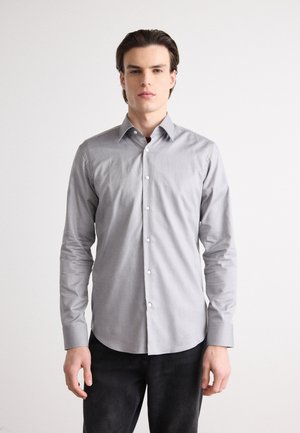 Chemise boutonnée grise en tissu texturé, dotée d'un col pointu, de manches longues et d'un ourlet droit avec de subtils détails de motif.