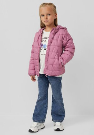 Roze pufferjack met capuchon en een doorgestikt ontwerp. Gecombineerd met een witte graphic t-shirt en blauwe flared jeans, afgemaakt met witte sneakers.