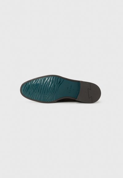 Semelle de chaussure avec un extérieur en caoutchouc noir et un motif texturé en teal. Présente un bord lisse et un logo en relief près du talon.