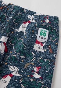 Moomin-themed fabric shorts featuring a dark blue background, playful character prints, and a white elastic waistband with a tag.
