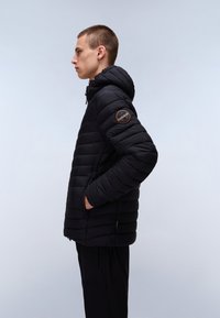Black puffer jacket with a hood, featuring quilted design, zipper closure, and side pockets. Includes a logo patch on the left arm.