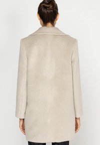 Jasnoszary płaszcz z miękkiego materiału, z klapami, długimi rękawami i prostym krojem z szwami na plecach.