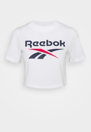 Balta trumpa medvilninė marškinėlių palaidinė su juodu ir raudonu Reebok logotipu, kuris turi kreivą dizainą. Trumpomis rankovėmis ir apvaliu iškirpimu.