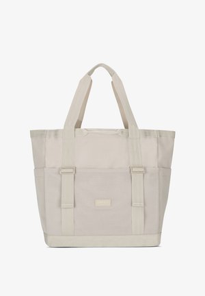Bolso tote de color beige claro con secciones de tela dual, con asas resistentes, un bolsillo de malla y una pequeña etiqueta con el logo en la base frontal.