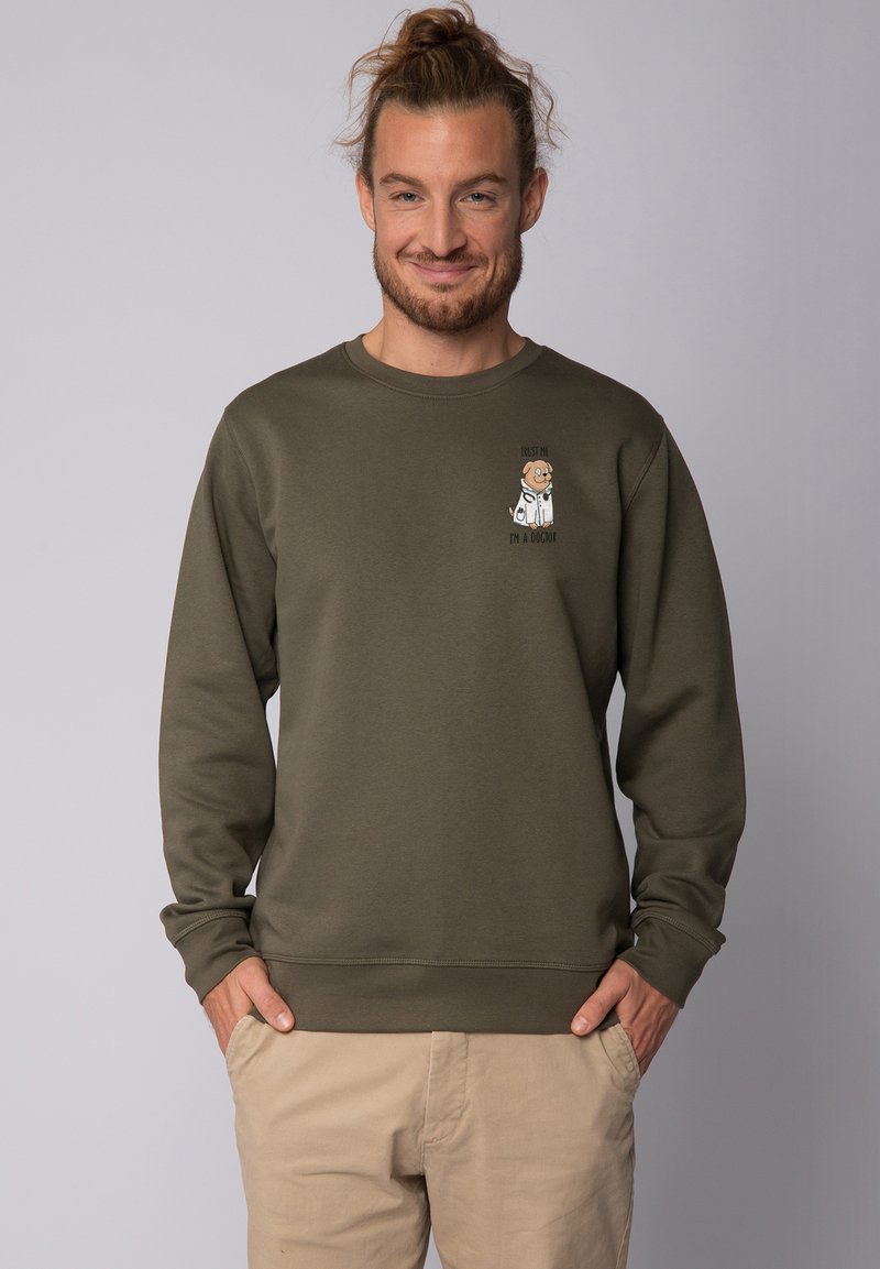 Olijfgroene trui van zachte stof, met een kleine afbeelding van een hond in een labjas en de tekst "Vertrouw me, ik ben een arts."