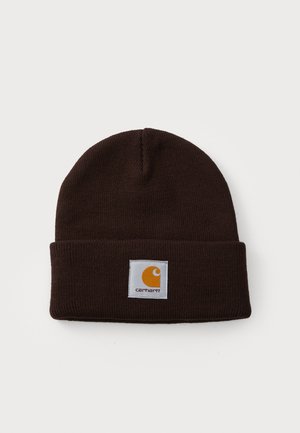 Brown knit beanie with a folded brim and a white patch featuring an orange logo. The texture is soft and ribbed throughout.