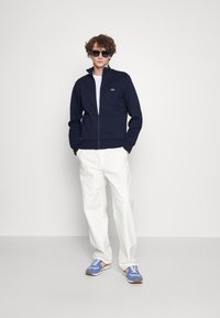 Lacoste - UNISEX - Jaka ar rāvējslēdzēju - marine Miniatūras attēls 1