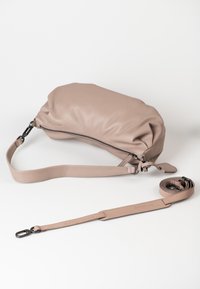 Licht taupe leren schoudertas met een zachte, ronde vorm, ritssluiting en een afneembare schouderband. Glad textuur met minimale accenten.