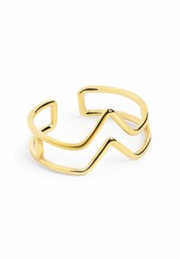 Gouden metalen armband met een zigzagontwerp en open uiteinden. Het oppervlak is glad en reflecterend, wat een minimalistische esthetiek benadrukt.