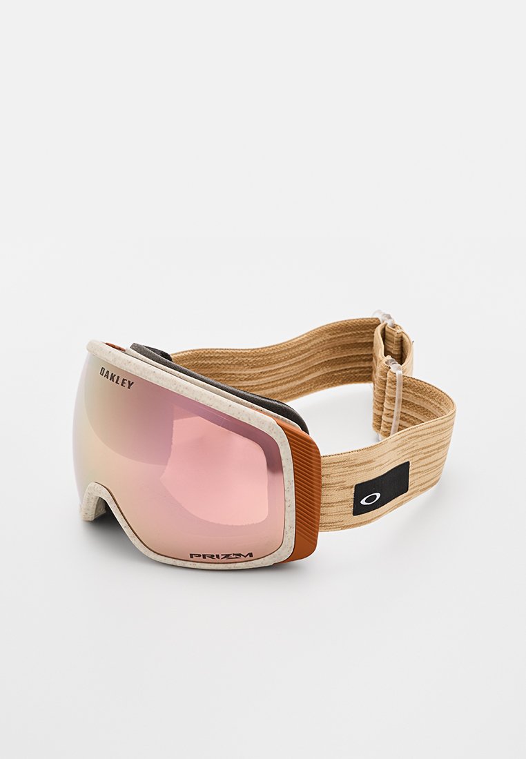 Oakley Skibrille mit einer abgerundeten Linse, rosa Tönung, grauen und orangefarbenen Akzenten sowie einem strukturierten beigen Band für sicheren Halt und Komfort.