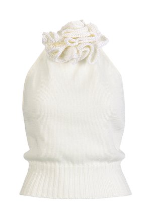 Femme portant un haut dos-nu blanc avec détail floral, un pantalon blanc à jambes larges, une ceinture marron clair, une pochette marron et des sandales à talons marron clair.