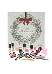 Adventtikalenteri juhlapäisellä seppelekuviolla, jossa on erilaisia vaaleanpunaisia ja mustia kosmetiikkatuotteita, kuten huulikiiltoa, poskipunaa ja luomiväripaletteja.