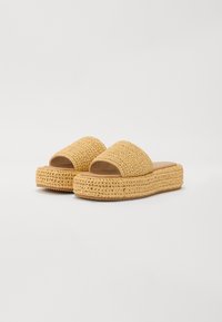 Sárga horgolt, slip-on stílusú szandálok, fonott mintával, vastag talppal és nyitott orral. Sima belső bélés.