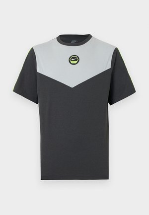 Tricou Nike cu mâneci scurte, în gri închis și gri deschis, cu un model în formă de chevron, logo circular verde și accente neon contrastante la umeri.