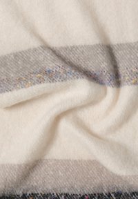 Wollmischung Decke mit cremefarbenen, grauen und schwarzen Streifen sowie bunten Tupfen, weicher Textur und einem gemütlichen, plüschigen Finish.