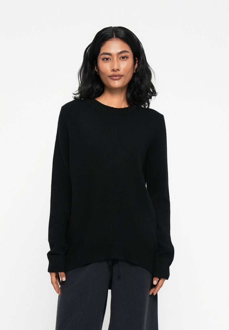 Sweater preto de malha com mangas longas, decote redondo e corte descontraído. Textura suave com punhos e barra canelados.
