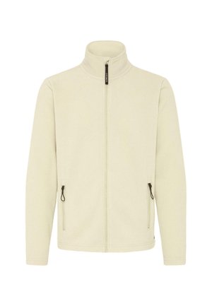 Šviesiai kreminės fleeco striukė su užtrauktuku priekyje, aukštu apykakle ir dviem šoninėmis kišenėmis. Yra juodos spalvos detalės ir lygi tekstūra.