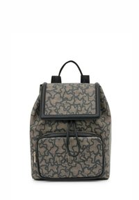 Mochila marrón con estampado, cierre de solapa, acentos de cuero, bolsillo frontal y dos correas ajustables de tela. Detalle de superficie texturizada.