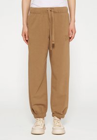 Bruine katoenen sweatpants met een elastische tailleband en boorden. Voorzien van een trekkoordsluiting en een logo op de zijkant.