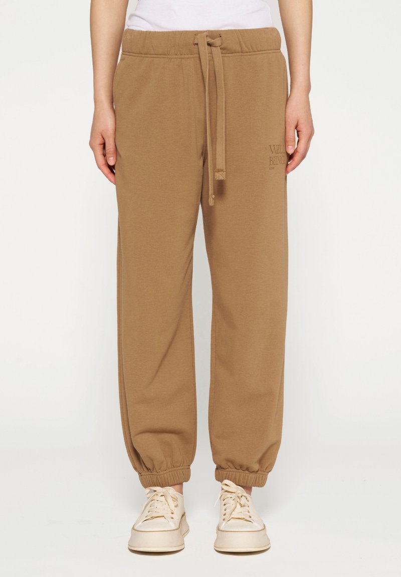 Bruine katoenen sweatpants met een elastische tailleband en boorden. Voorzien van een trekkoordsluiting en een logo op de zijkant.