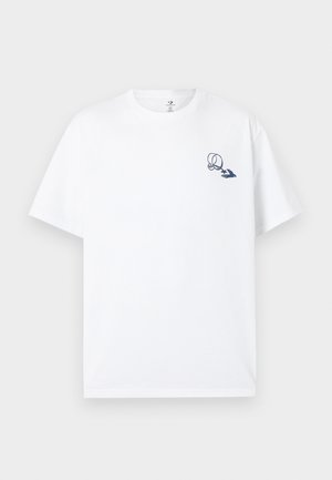 Vit bomullst-shirt med korta ärmar, med en marinblå grafisk design på vänstra bröstet. Klassisk rund halsringning.