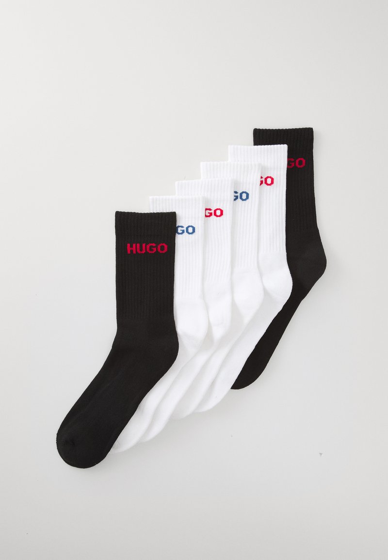 Baumwollsocken in Schwarz und Weiß mit gerippter Textur und dem Logo "HUGO" in Rot und Blau an den Bündchen. Set aus fünf Paaren.