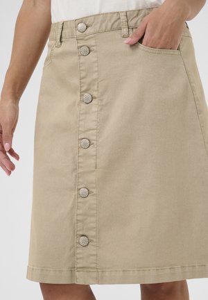 Beige denim rok met een a-lijn vorm, voor sluiting met knopen en zijzak; heeft decoratieve metalen knopen aan de voorkant.